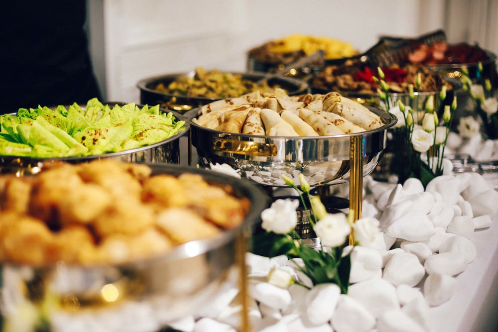 A catering buffet with chafing dishes and fresh flowers